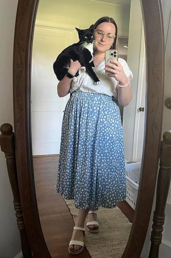 Reviewer in a blue high waisted skirt with white polka dots 