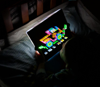 reviewer's child looking at the product in a dark bedroom