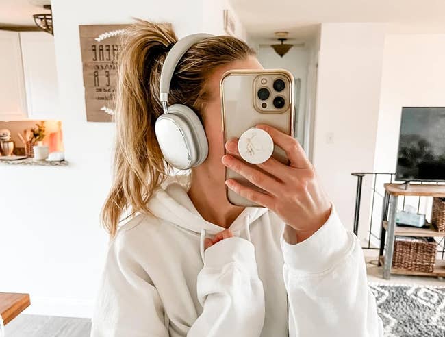 Reviewer selfie wearing silver over-ear headphones