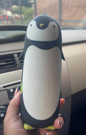 reviewer holding a penguin shaped water bottle 
