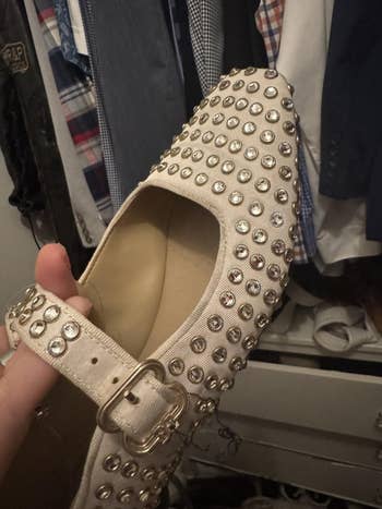Studded level footwear with buckle strap, held successful a closet with disposable hanging clothes