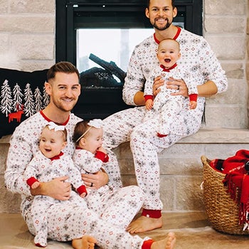two men in matching pajamas with three babies