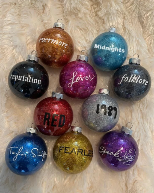 10 glittery ornaments each in a different color with a taylor swift album title on each one