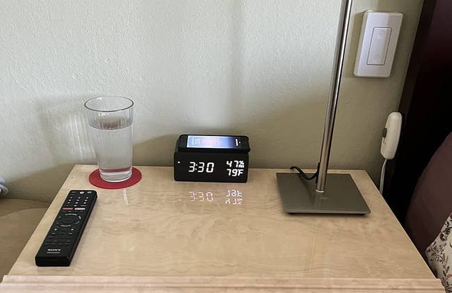 Reviewer's bedside table with alarm clock and phone charging on top