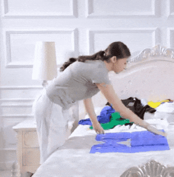gif of someone using the blue laundry folding board to quickly fold some shirts