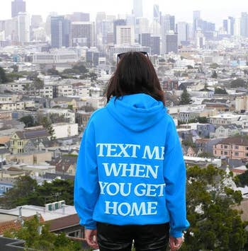 a model wearing a bright blue hoodie that says 