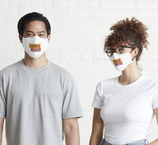 two people wearing white non medical face masks with the camp rock logo on it 