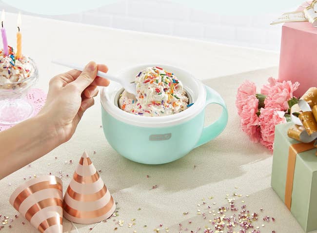 Person holding a spoon with crystal pick successful a greenish mug, surrounded by enactment hats and decorations.