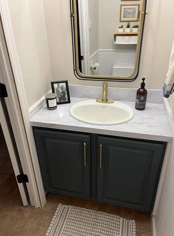 same reviewers bathroom counter with top covered in marble contact paper