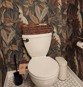 reviewer photo of the white and gold garbage can in their bathroom