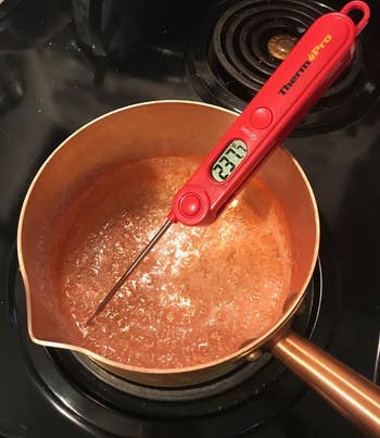 reviewer photo of the red thermometer reading the temperature of a pot filled with boiling sugar