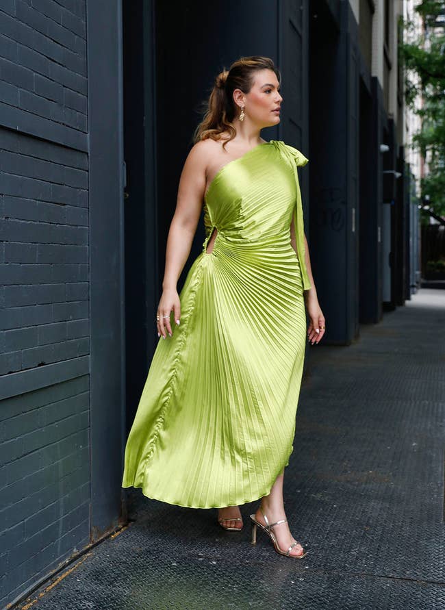 model in pleated chartreuse one shoulder midi dress with side cutout