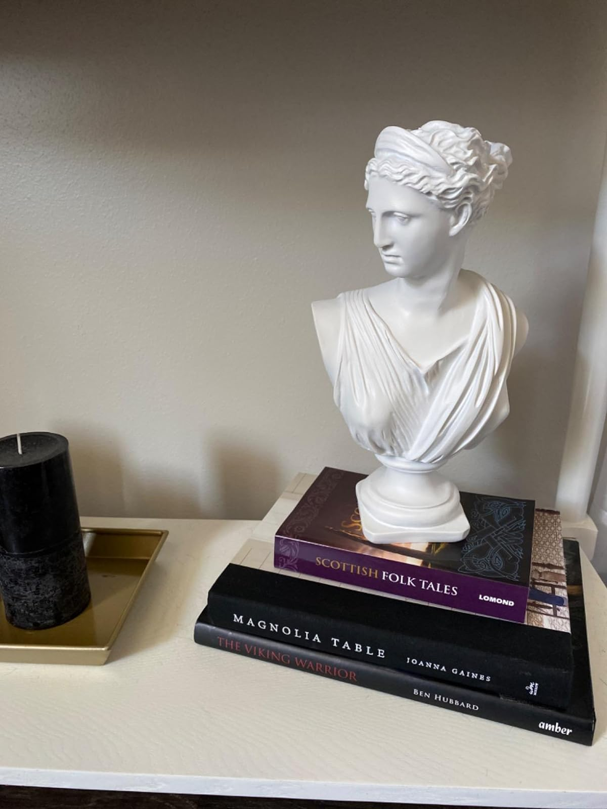 Reviewer's bust is placed on top of a large books