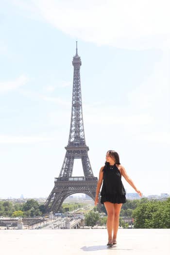 Person successful a abbreviated achromatic formal lasting adjacent the Eiffel Tower, looking to the side