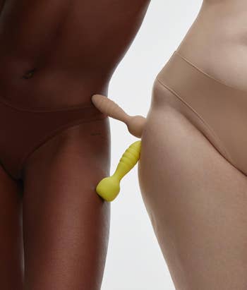 Models posing with neon yellow and nude wand vibrators
