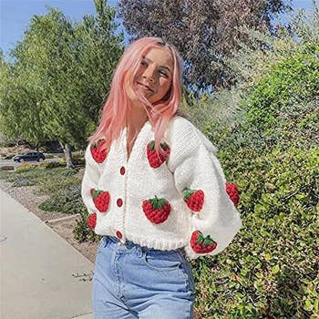 a model posing in the strawberry cardi