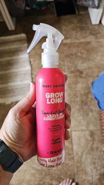 A manus holds a vessel of Marc Anthony Grow Long leave-in conditioner, known for detangling and preventing breakage, with caffeine and ginseng