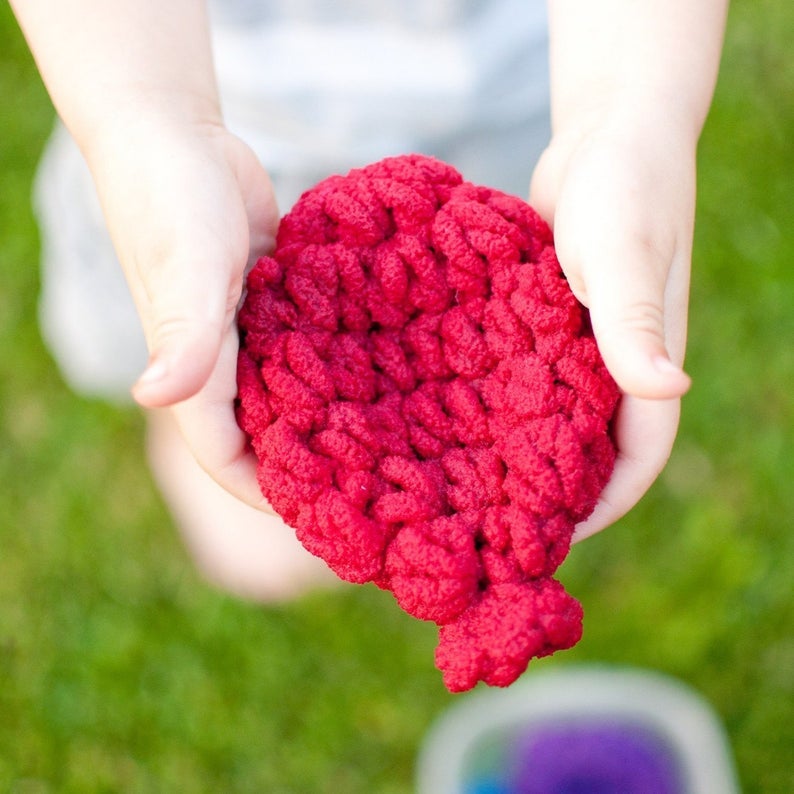 person's hands holding the knitted yarn balloon-shaped toys
