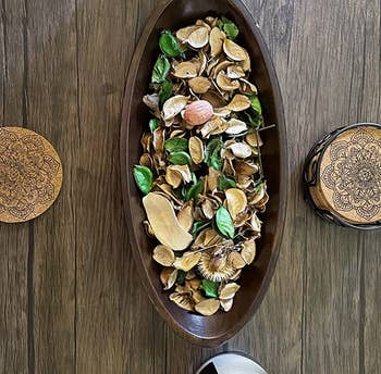 reviewer photo of the green and beige potpourri in an ovular tray