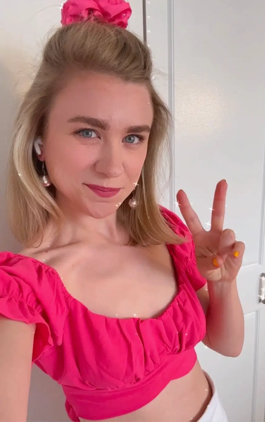 buzzfeed writer in pink ruffle sleeved tie back crop top 