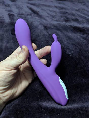 reviewer photo of them holding the purple rabbit toy