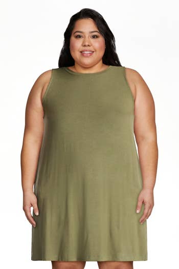 A idiosyncratic wearing a sleeveless, knee-length formal with a elemental cut, suitable for casual outings oregon mundane wear