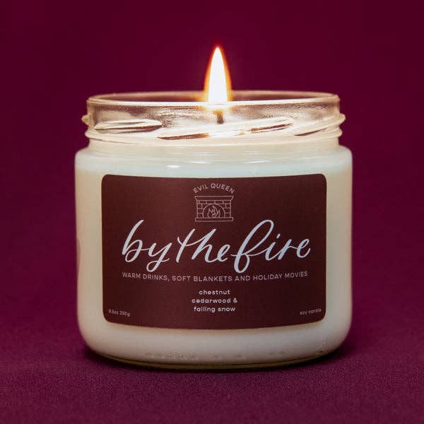 a white candle with a maroon label that says 