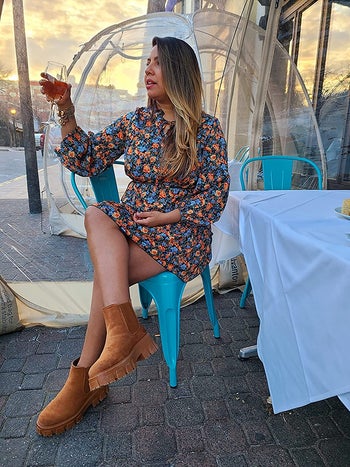 reviewer photo wearing floral minidress, holding wine glass
