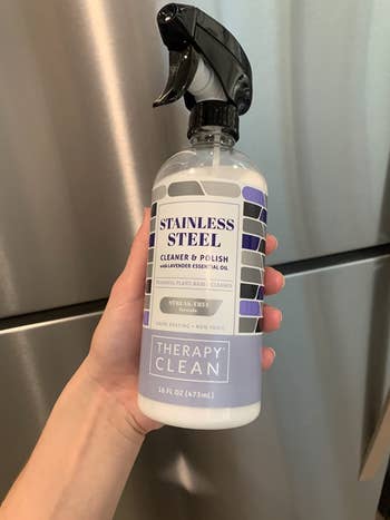 Reviewer holding bottle of the cleaner