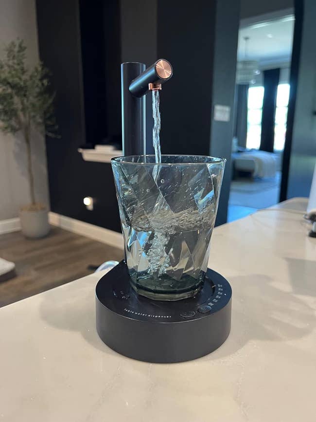 black water dispenser pouring water into glass