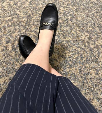 Person wearing a striped garment with a black, buckled shoe, suitable for a professional setting