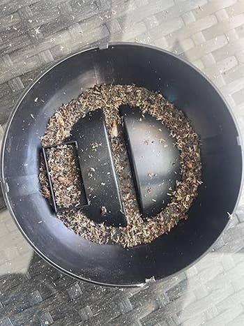 Close-up of birdseed remnants successful  a ample  achromatic  vessel  placed connected  a wicker surface, perchance  aft  being utilized  to provender  birds