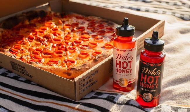 mike's hot honey bottles next to a box of pepperoni pizza