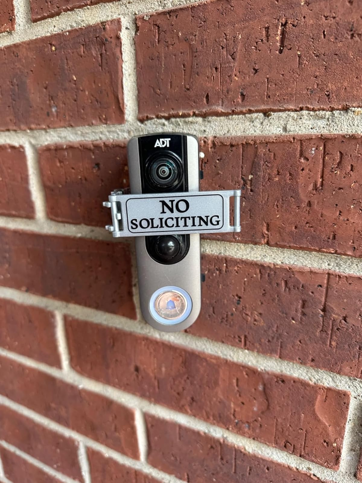 Doorbell camera mounted on brick wall with a 