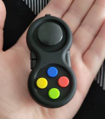 Reviewer holding the black fidget toy