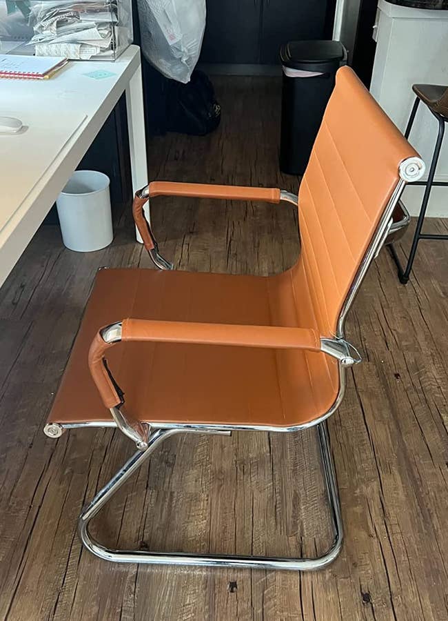 a reviewer photo of the chair in brown with a silver base 