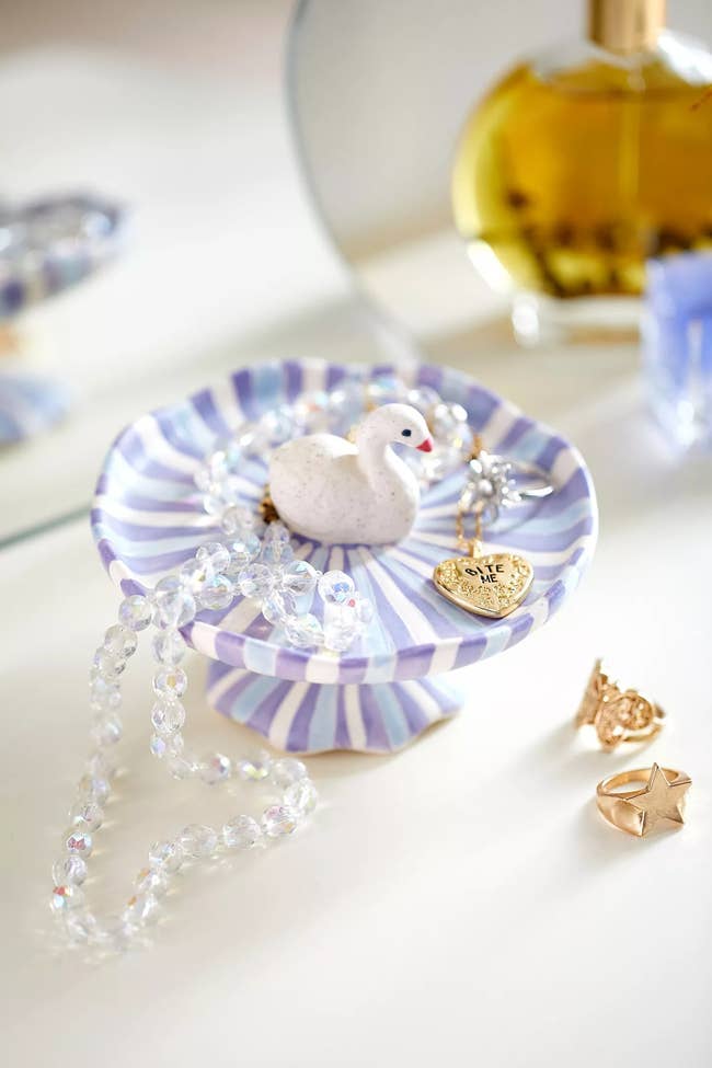 white blue and lavender striped elevated trinket dish with swan figure in the middle