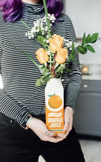 reviewer holding the orange juice vase