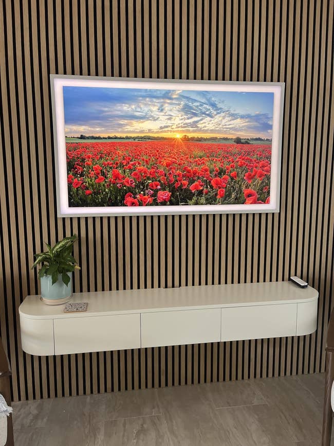 Wall-mounted integer creation show featuring a sunset implicit a immense tract of poppies, with a sleek floating support beneath holding a tiny plant