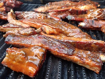 ribs on a grill that are covered in the bbq sauce