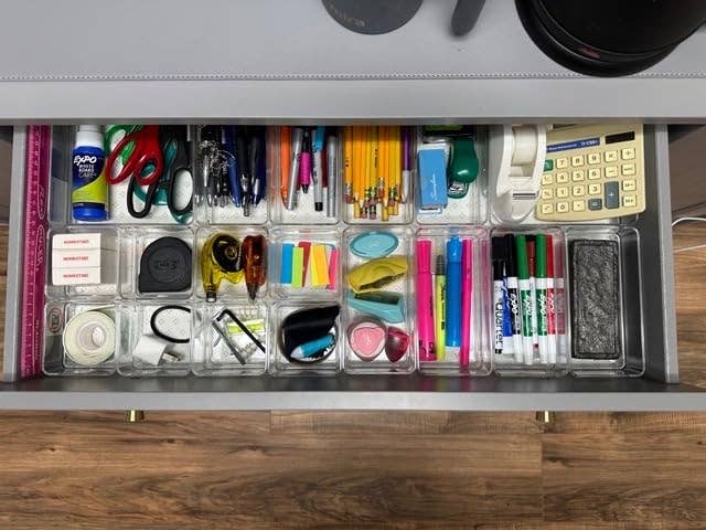 a desk drawer organized using clear bins