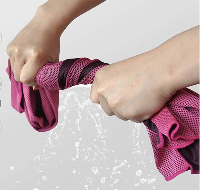 a person wringing out a pink towel