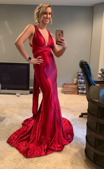 A reviewer wearing the dress in red 