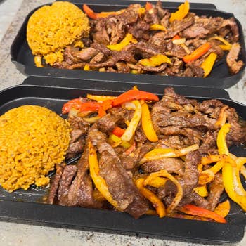 Two trays of beef stir-fry with bell peppers and a side of seasoned rice, ideal for meal prep or takeout