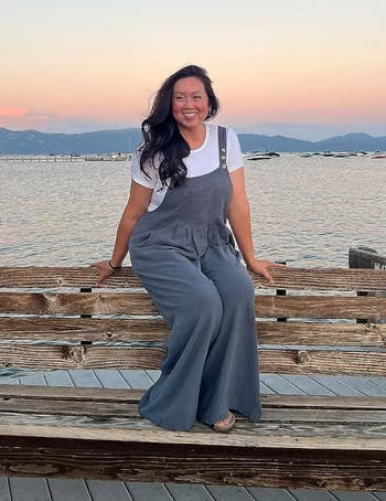 reviewer sitting, posing wearing the overalls in grey blue