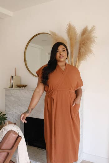 Person successful  a stylish wrapper  formal  poses indoors, with a decorative reflector  and pampas writer  connected  a mantel down  them