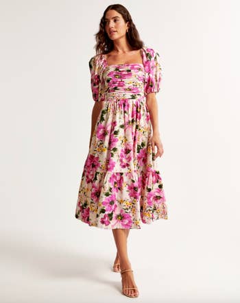 Model in a floral dress with puff sleeves and tiered skirt