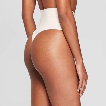 side of a model wearing a nude, seamless, and high-waisted thong