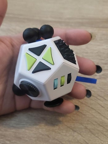 A reviewer holding the fidget toy