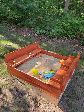 an outdoor sandbox with built-in benches